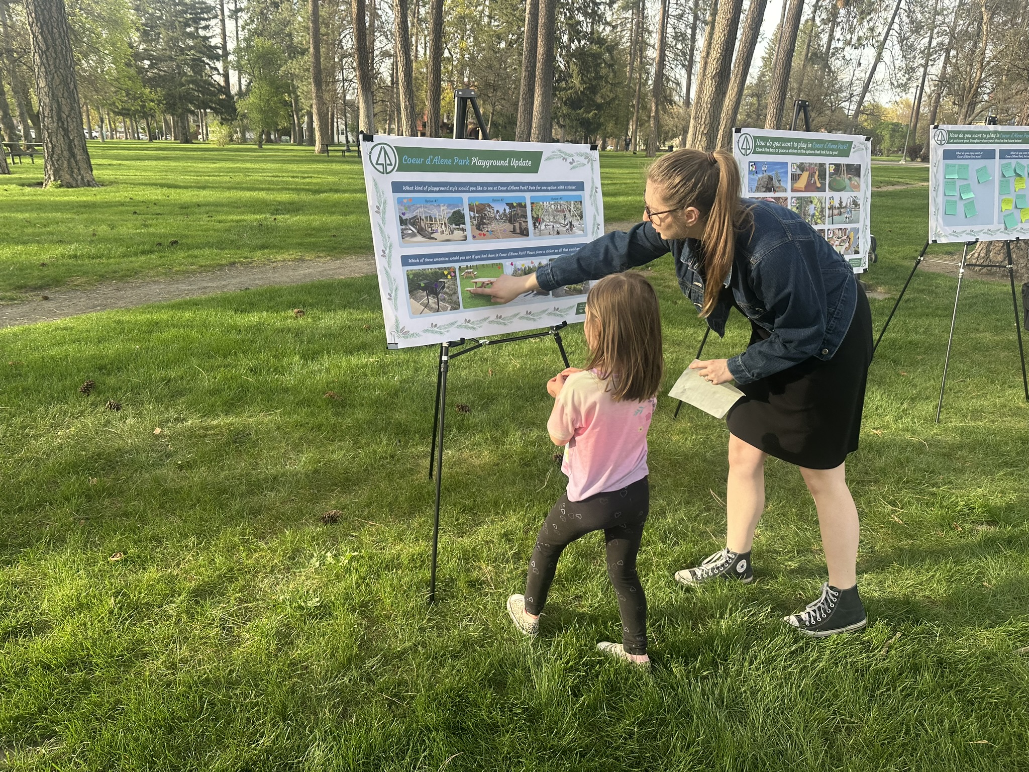 Park consultant showing child playground options at pop-up